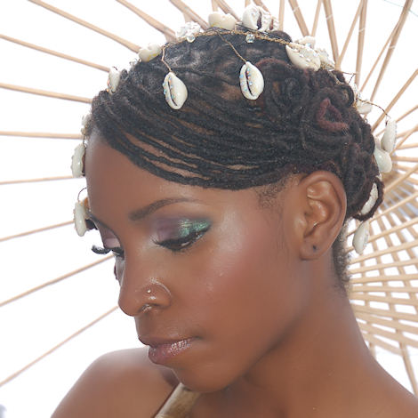 black woman with loced bridal hairstyle and cowrie shells