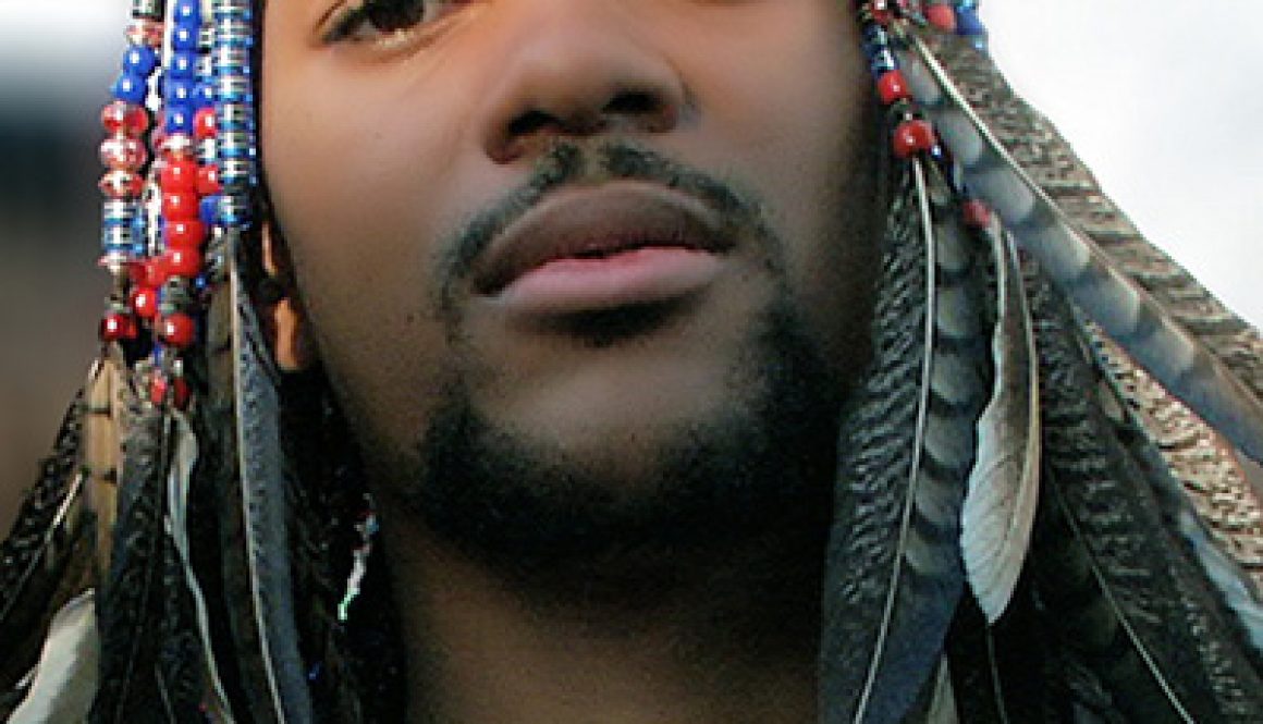 Black Man with cornrows adorned with feathers and beads